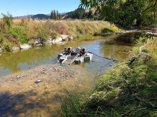 Gold dredge in river bank